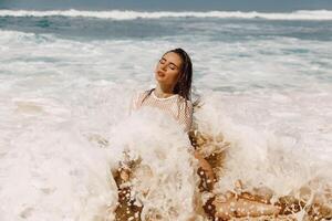 atraente jovem mulher dentro bikini posando às oceano de praia. foto