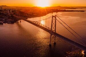 hercílio luz ponte com caloroso pôr do sol dentro Florianópolis. aéreo Visão foto