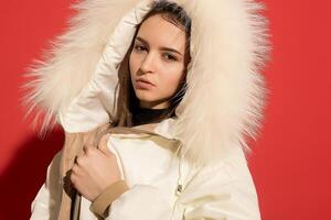 menina branco Jaqueta poses vermelho fundo foto