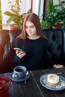 jovem feliz fêmea lendo Boa notícia em dela Móvel telefone foto