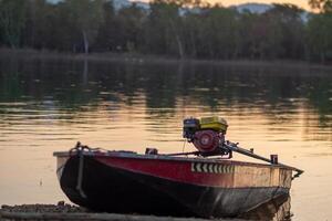 barco deriva pacificamente em sereno rio abaixo dourado pôr do sol foto