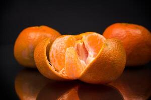 maduro tangerinas com descasca em Preto fundo foto
