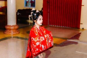 mulher vestir China Novo ano. retrato do uma mulher. pessoa dentro tradicional fantasia. mulher dentro tradicional fantasia. lindo jovem mulher dentro uma brilhante vermelho vestir e uma coroa do chinês rainha posando. foto