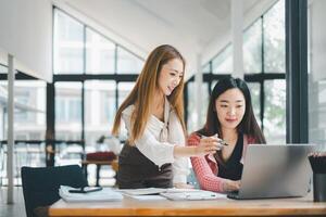 o negócio equipe analytics conceito, dois acionado fêmea colegas discutindo trabalhos projetos em uma computador portátil dentro uma brilhante moderno escritório contexto. foto