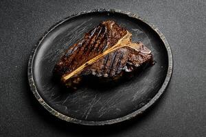 grelhado t-bone bife. carne bife em uma de madeira Preto placa. eu no. foto