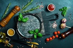 cozinha bandeira. uma cozinha mesa em que vegetais, especiarias e uma metal bandeja estão liderar fora. em uma Sombrio pedra fundo. livre espaço para texto. foto