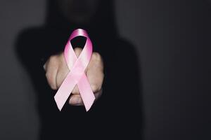 Rosa fita para seio Câncer conhecimento, simbólico arco cor levantando consciência em pessoas vivo com mulheres seio tumor doença. foto