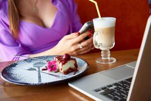 a imagem do uma feliz mulher usando uma computador portátil enquanto sentado dentro uma cafeteria. manhã luz café da manhã para uma o negócio senhora. foto