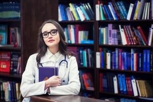 médico lindo médico aluna dentro biblioteca fundo foto
