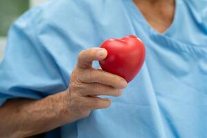 médico segurando uma vermelho coração dentro hospital, saudável Forte médico conceito. foto