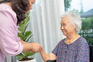 cuidador Socorro ásia Senior mulher em cadeira de rodas com amor às lar. foto