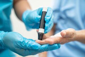 médico Verifica diabetes a partir de dedo sangue açúcar nível com dedo lanceta. foto