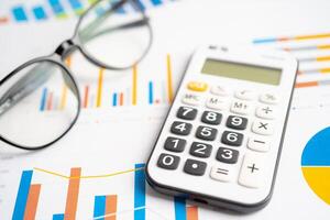 óculos com calculadora em gráfico gráfico papel. finança, conta, estatística, investimento dados economia, estoque troca negócios. foto