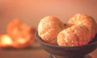 tangerinas dentro uma argila prato e descasca em a mesa foto