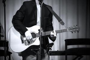 homem tocam clássico guitarra contra a cortina foto