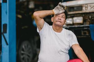 ásia masculino trabalhador cansado Exausta fadiga a partir de trabalho duro dentro quente e sujo local de trabalho mau trabalho bem-estar foto