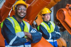 Preto africano engenheiro equipe trabalhador em pé dentro robótico braço fábrica. serviço trabalho em equipe cara. foto