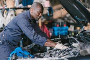 garagem mecânico africano Preto masculino profissional trabalhando carro auto serviço verificação motor óleo foto