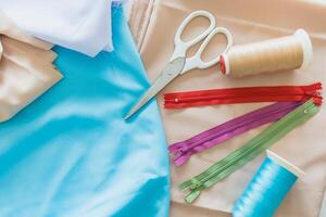 colorida fechos tesouras e carretéis do fio deitar em tecidos têxtil pano para alfaiate equipamento decoração conceito foto