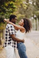 encontro casal homem e mulheres namorados dia. africano Preto amante às parque ao ar livre verão estação vintage cor tom foto