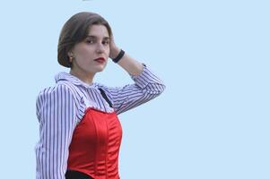 à moda caucasiano menina dentro uma branco camisa e vermelho principal, isolado em uma azul fundo. livre espaço para texto. foto