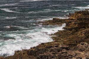 as ondas lutando sobre a costa rochosa deserta do oceano atlântico, portugal foto