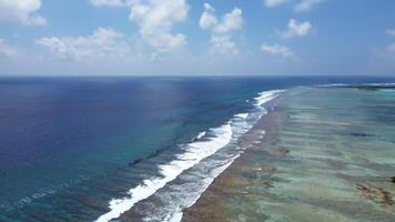 zangão Visão do paraíso ilhas do a Maldivas com coral recifes debaixo a ondas do azul a indiano oceano. foto