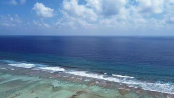 zangão Visão do paraíso ilhas do a Maldivas com coral recifes debaixo a ondas do azul a indiano oceano. foto