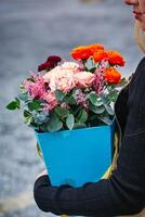 mulher segurando azul vaso preenchidas com flores foto