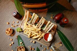 de madeira bandeja com metade sanduíche e francês fritas foto