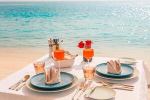 mesa de café da manhã de luxo lindo fundo do céu do mar tropical. manhã romântica idílica ama o tempo dos casais nas férias de verão. conceito de férias de romance de lua de mel. viagens e estilo de vida, destino gastronômico foto