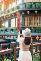 mulher viajante visitando dentro Taiwan, turista levando foto e passeios turísticos dentro Jiufen velho rua Vila com chá casa fundo. ponto de referência e popular atrações perto Taipei cidade. viagem conceito