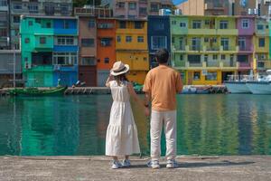 casal viajante visitando dentro Taiwan, turista passeios turísticos dentro keelung, colorida Zhengbin pescaria porta, ponto de referência e popular atrações perto Taipei cidade. viagem, amor, juntos e verão período de férias conceito foto