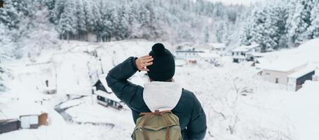 mulher turista visitando ginzan Onsen dentro Yamagata, feliz viajante passeios turísticos japonês Onsen Vila com neve dentro inverno temporada. ponto de referência e popular para atração dentro Japão. viagem e período de férias conceito foto