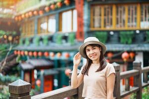 mulher viajante visitando dentro Taiwan, turista com chapéu passeios turísticos dentro Jiufen velho rua Vila com chá casa fundo. ponto de referência e popular atrações perto Taipei cidade . viagem e período de férias conceito foto