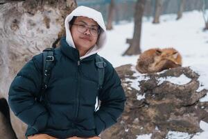 homem turista com fofa Raposa em neve dentro inverno estação às zao Raposa Vila, viajante passeios turísticos miyagi prefeitura. ponto de referência e popular para atração perto Sendai, tohoku, Japão. viagem e período de férias foto