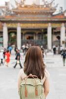 mulher viajante visitando dentro Taiwan, turista com chapéu passeios turísticos dentro Longshan têmpora, chinês folk religioso têmpora dentro wanhua distrito, Taipei cidade. ponto de referência e popular. viagem e período de férias conceito foto