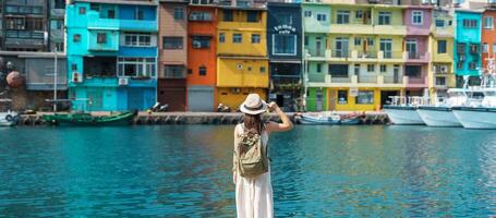 mulher viajante visitando dentro Taiwan, turista com mochila e chapéu passeios turísticos dentro keelung, colorida Zhengbin pescaria porta, ponto de referência e popular atrações perto Taipei cidade . Ásia viagem conceito foto