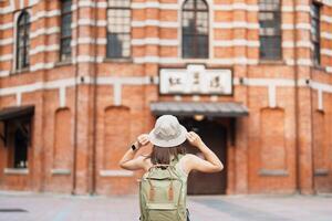 mulher viajante visitando dentro Taiwan, turista passeios turísticos às vermelho casa ou velho teatro dentro Ximen, Taipei cidade. ponto de referência e popular atrações. Ásia viagem, viagem e período de férias conceito foto