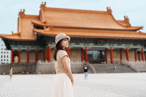 mulher viajante visitando dentro Taiwan, turista com chapéu passeios turísticos dentro nacional Chiang kai shek memorial ou corredor liberdade quadrado, Taipei cidade. ponto de referência e popular atrações. Ásia viagem conceito foto