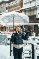 mulher turista visitando ginzan Onsen dentro Yamagata, feliz viajante passeios turísticos japonês Onsen Vila com neve dentro inverno temporada. ponto de referência e popular para atração dentro Japão. viagem e período de férias conceito foto