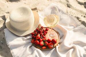 Palha de praia chapéu com borda para Sol proteção com uma prato do fruta e vinho. foto