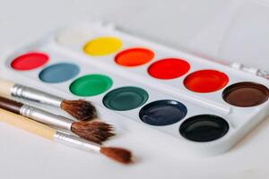 aguarela multicolorido tintas fechar-se com escovas para desenhando foto