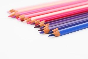 multicolorido lápis mentira em uma branco mesa, a tolet alcance do cores foto
