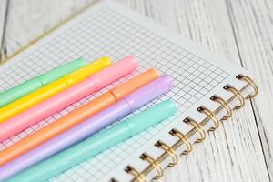 caderno diário para planejamento e estudando em a mesa com colori marcadores. foto