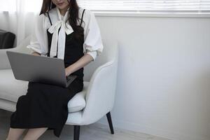 uma japonês mulher digitando computador portátil de controlo remoto trabalhos dentro a escritório sem rosto composição foto