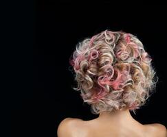 fêmea Penteado com ondulado multi colori cabelo costas Visão em Preto fundo. foto