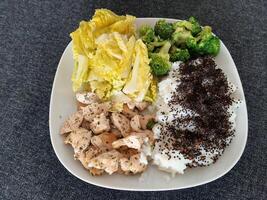 caseiro grelhado frango com arroz e brócolis, servido em uma branco prato foto