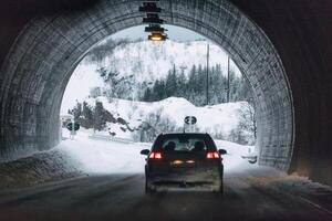 traseiro carro dirigindo dentro montanha túnel em inverno foto