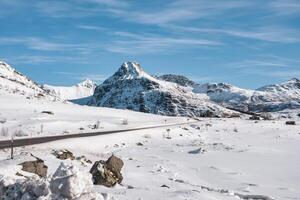 Nevado montanha alcance e a estrada dentro inverno em ensolarado dia às lofoten ilhas foto